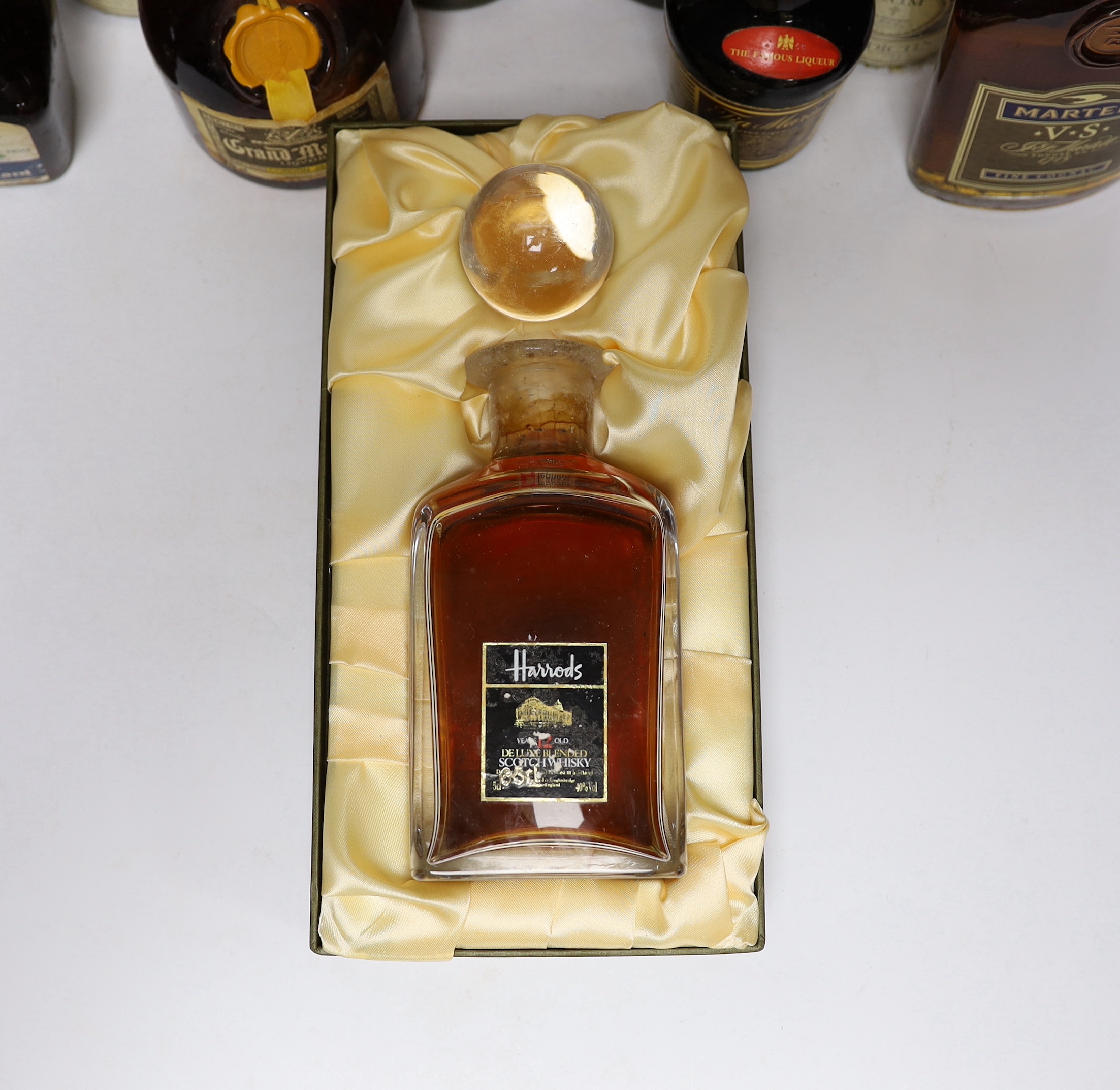 A bottle of Harrods Whisky, 12 years old, two bottles of Janneau VSOP Grand Armagnac, a bottle of Grand Marnier Cordon Jaune, one and a half bottles of D.O.M Benedictine, half a bottle of Martell V.S Fine Connacht, a bot